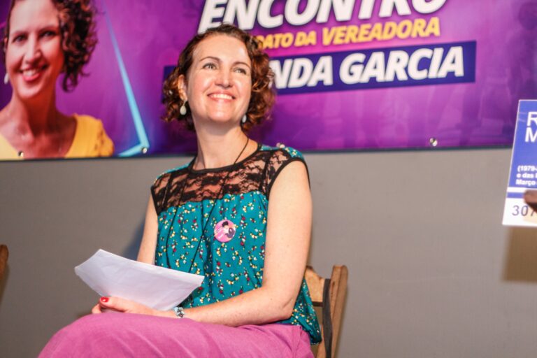 Vereadora Fernanda Garcia durante a plenária do seu mandato em 2023. Na foto, ela está sentada sorrindo e olhando para sua direita